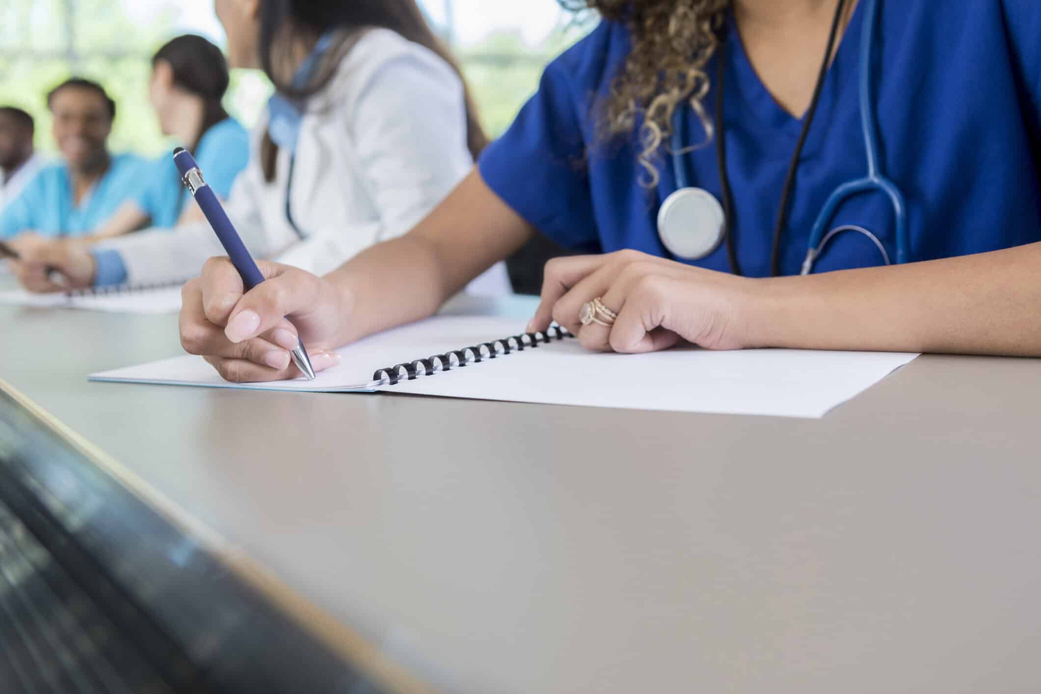 allied health student writes in class workbook