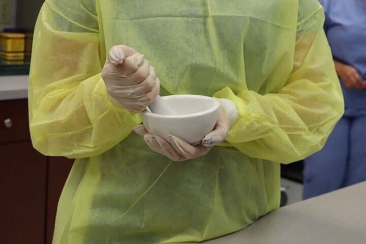 An FVI miami pharmacy technician program student practicing mixing and compounding in the pharmacy lab