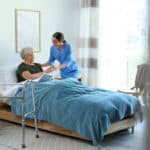 A Miramar nursing assistant home health aide program graduate working in hospice care - assisting a client in their bed at their home