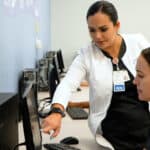 a nursing professor showing the laptop to a Miami ASN nursing school student