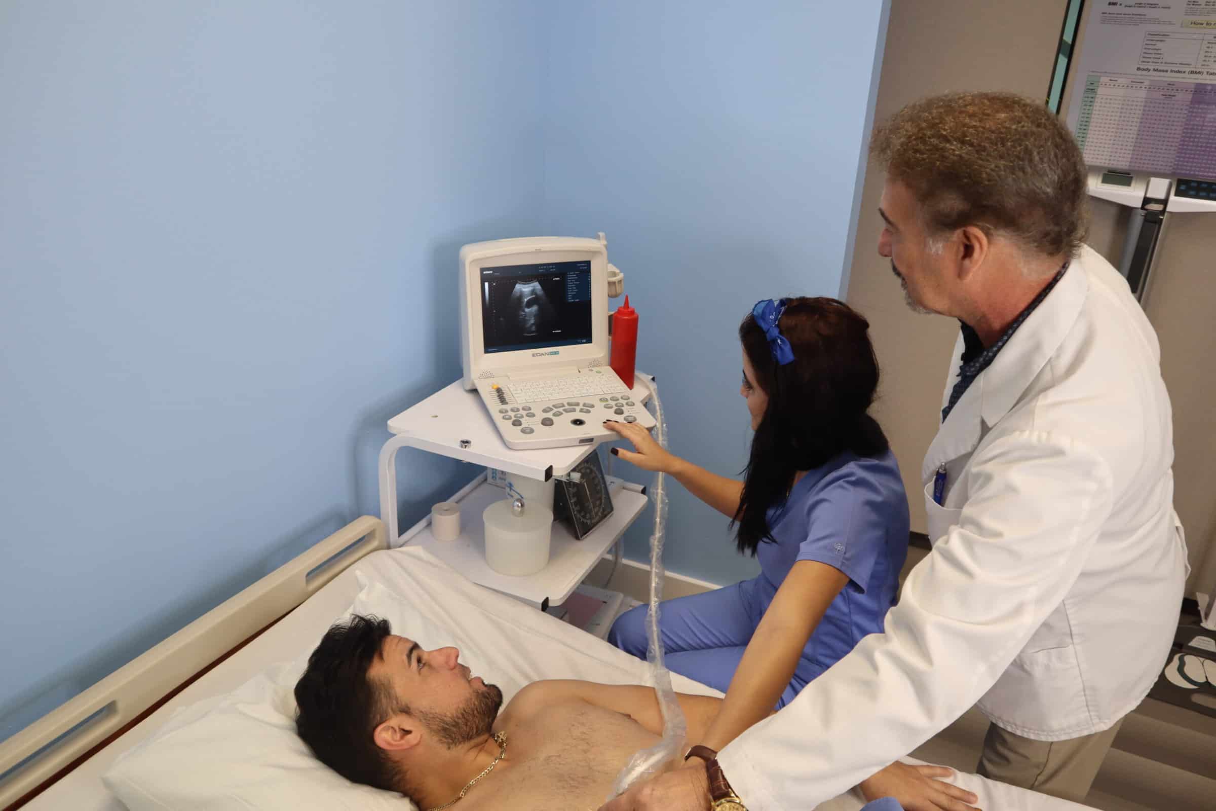 An FVI instructor assists Miami medical assistant training program student with performing a basic EKG medical test on another student