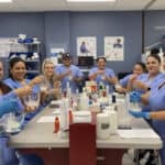 miami pharmacy technician school students smiling at the camera while they practice