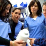 FVI Miami pharmacy technician program students gathered together looking at pills