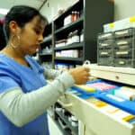 Miami pharmacy tech training: student putting away medicine