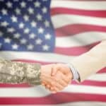 veterans shaking hands in front of US flag