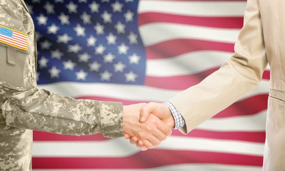 veterans shaking hands in front of US flag