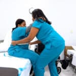 Miami home health aide school students practicing skills with each other in a skills lab