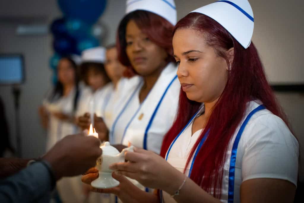 miramar asn nursing school graduate lighting her candle during the pinning ceremony