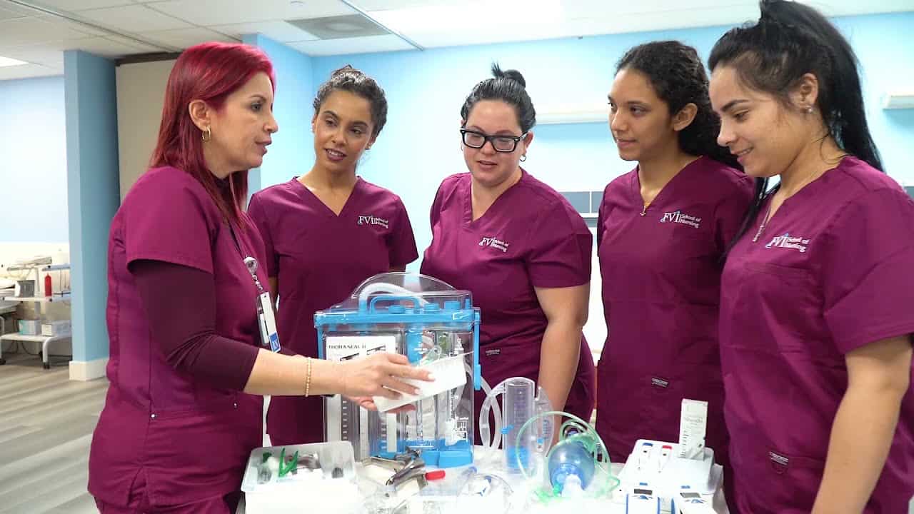 An instructor and miami lpn practical nursing school students on campus doing hands-on practice