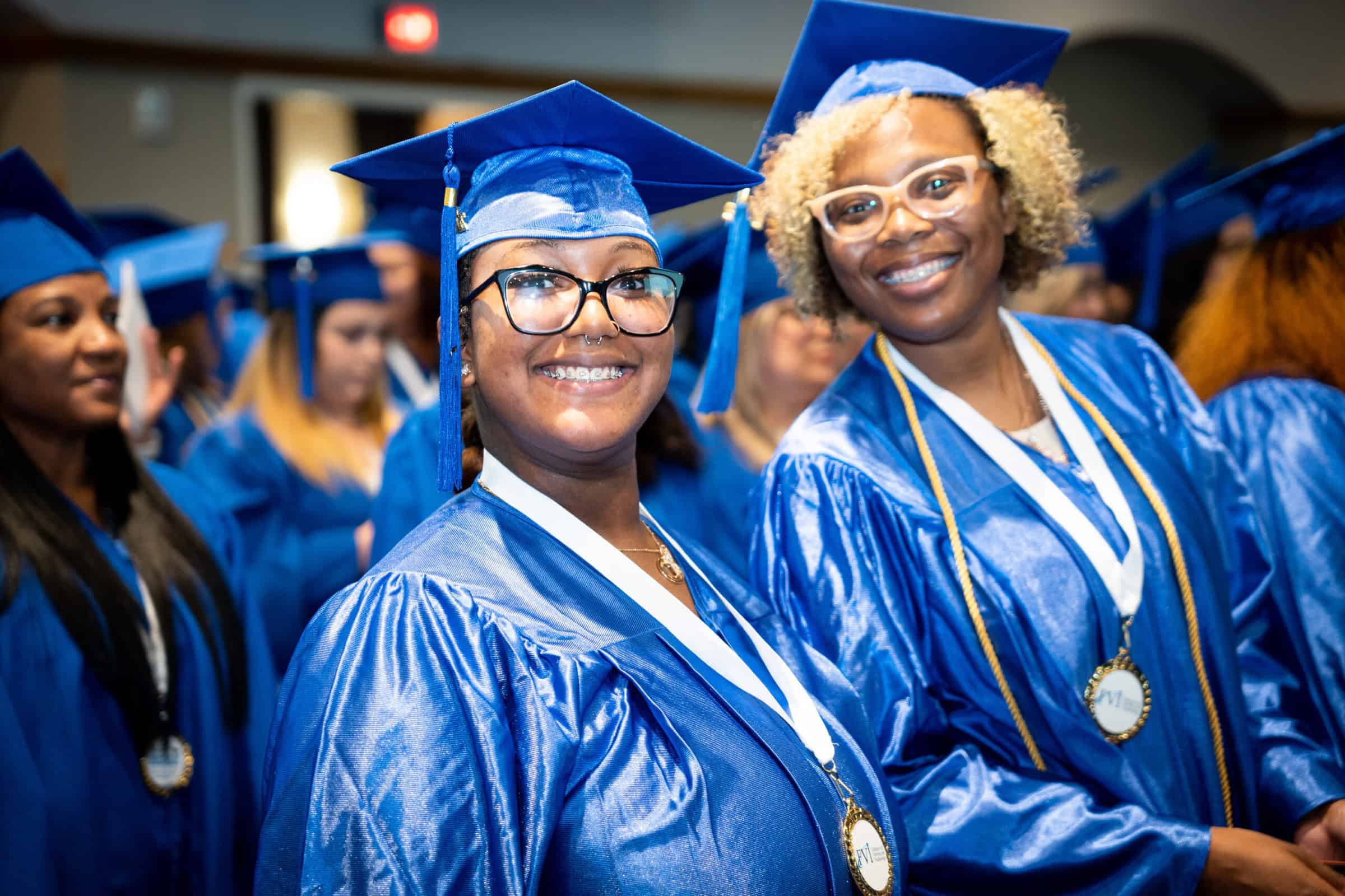 2 florida allied health diploma graduates smiling at an FVI graduation