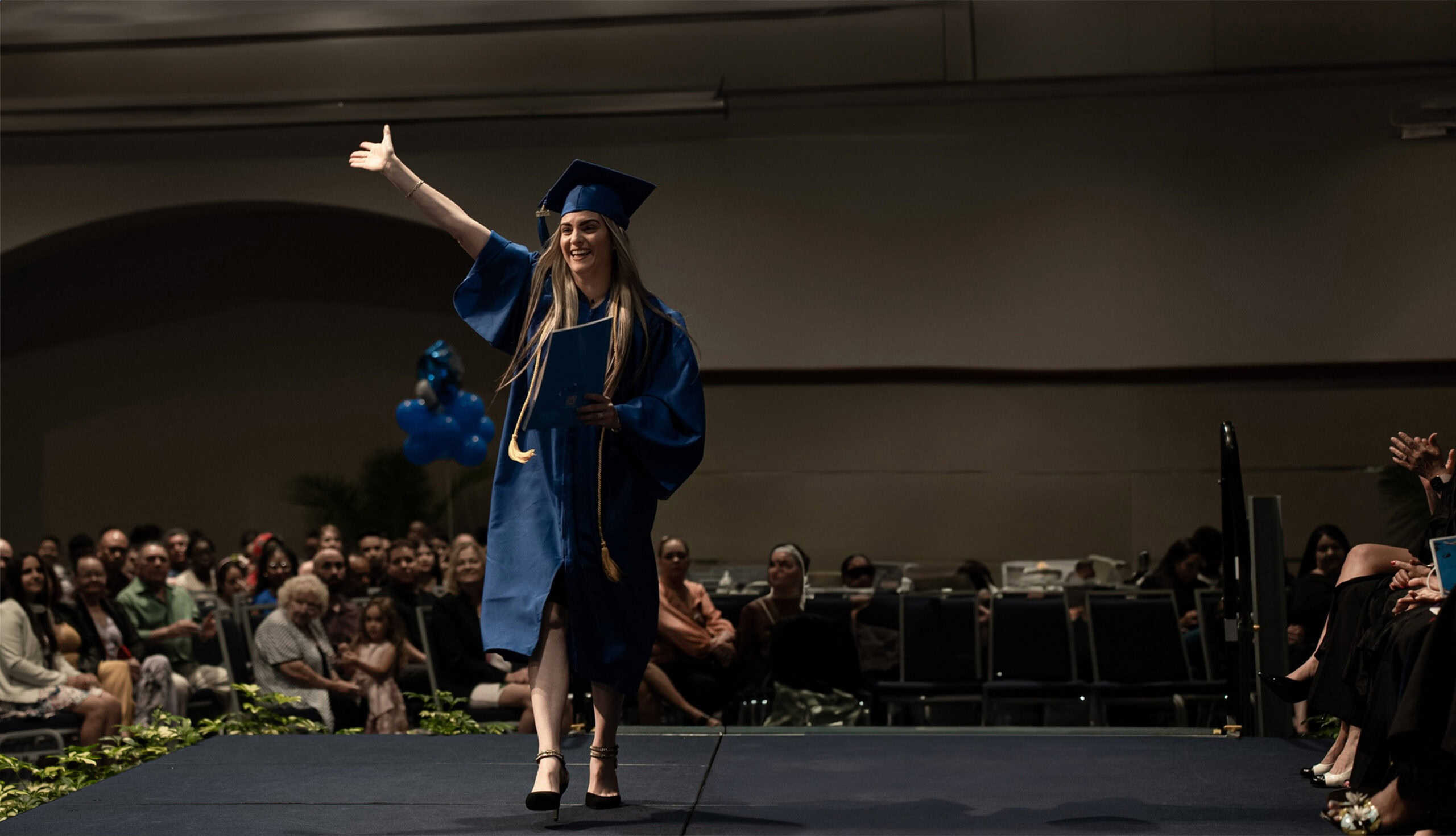 An excited FVI school graduate walking across the stage a graduation