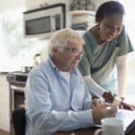 in home health aide helping elderly man