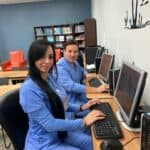 Two FVI Miramar allied health school students in scrubs working at the lab