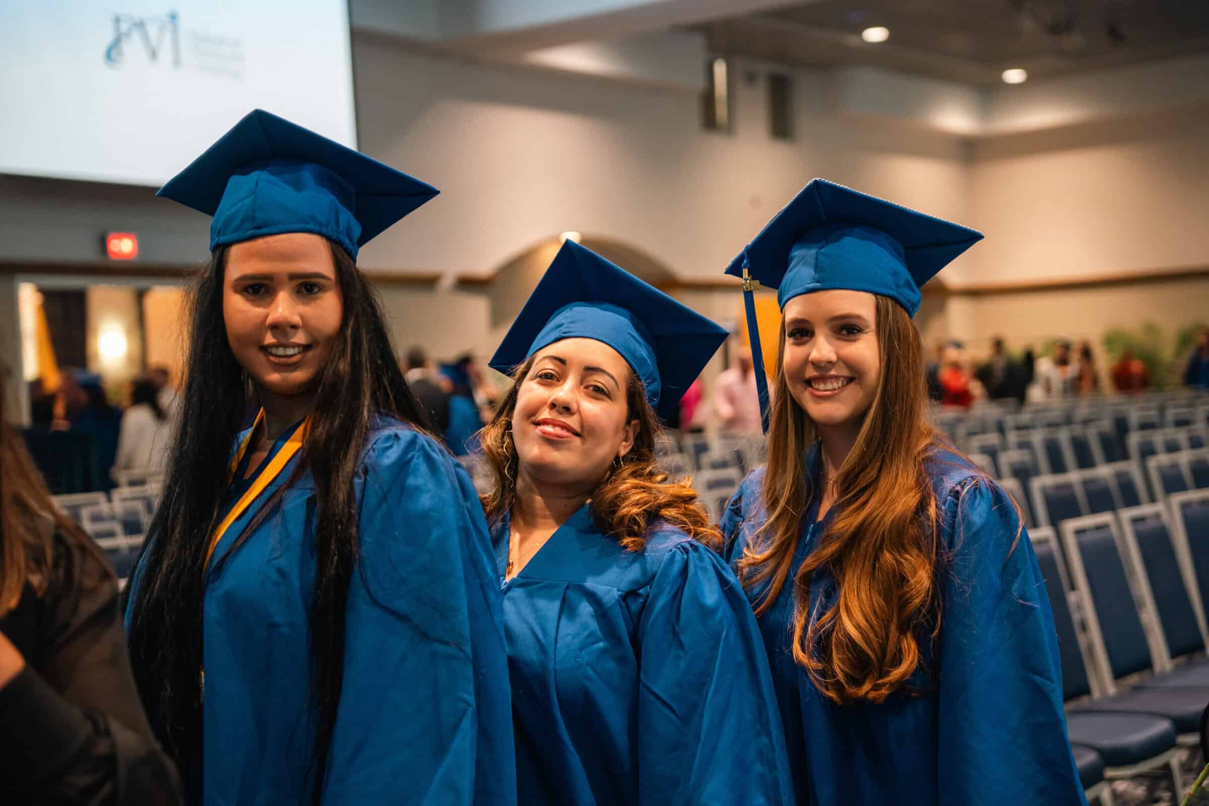 three Miami allied health program graduates posing during graduation