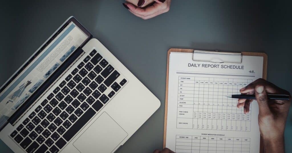 laptop and daily report scheudle paper