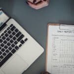 laptop and daily report scheudle paper