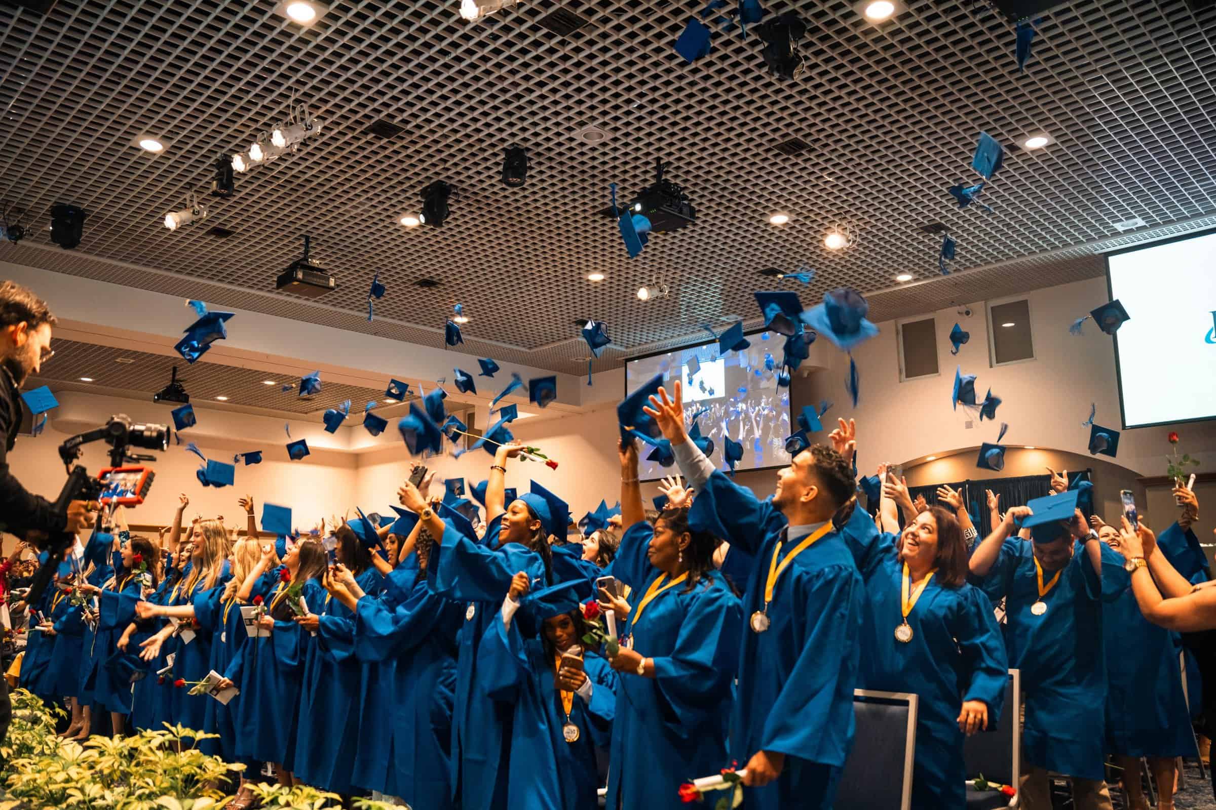 students throwing their caps at the end of nursing school graduation