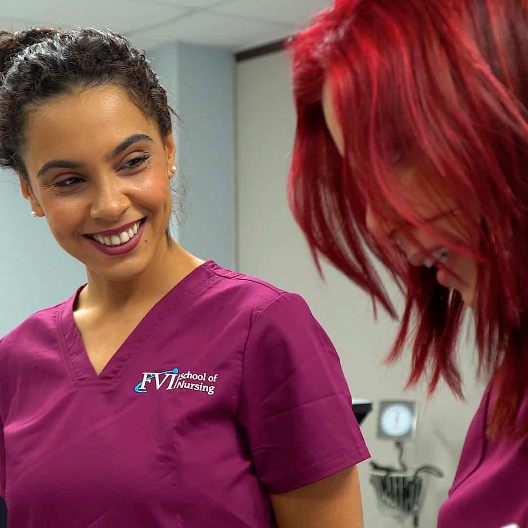 Practical Nursing student ar FVI smiling while receiving guidance from her instructor during practical nursing clinical practice in Miami